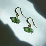 Raw drilled Chlum Moldavite earrings with naturally rounded green stones and gold-plated hooks.