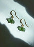 Raw drilled Chlum Moldavite earrings with naturally rounded green stones and gold-plated hooks.