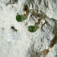 Raw drilled Chlum Moldavite earrings with naturally rounded green stones and gold-plated hooks