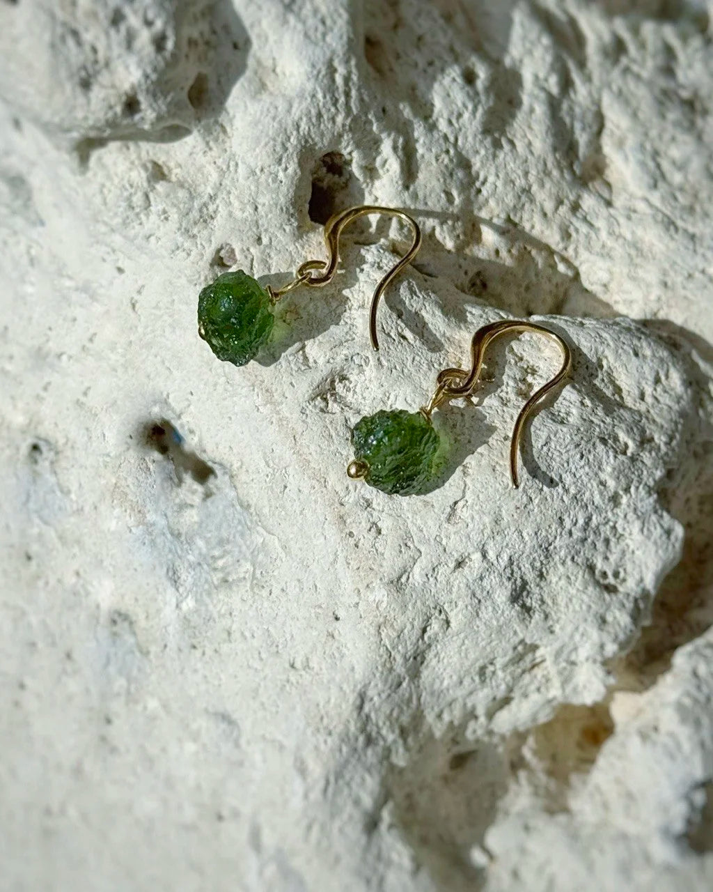Raw drilled Chlum Moldavite earrings with naturally rounded green stones and gold-plated hooks
