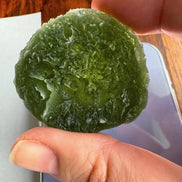 Hand holding 35g Moldavite from Bartochov, Czech Republic