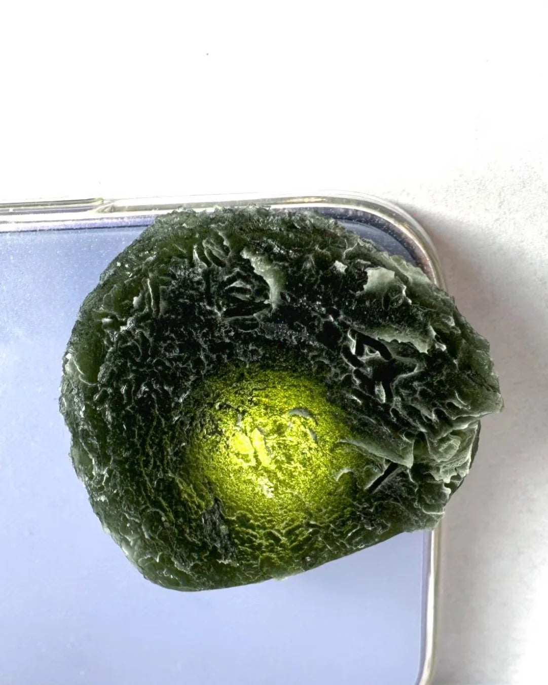 Large Bartochov Moldavite illuminated to reveal its translucent green colour