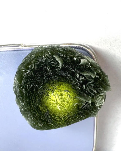 Large Bartochov Moldavite illuminated to reveal its translucent green colour