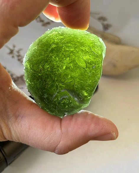 Large Bartochov Moldavite illuminated to reveal its translucent green colour