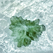 Transparent 1.34g Ježkovna Moldavite with spiked sculpting and a large open bubble
