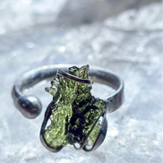Adjustable moldavite ring with a 0.87g transparent green stone from Nesměň, featuring spiked sculpting in a tin and silver alloy setting.