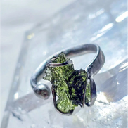 Adjustable moldavite ring with a 0.87g transparent green stone from Nesměň, featuring spiked sculpting in a tin and silver alloy setting.