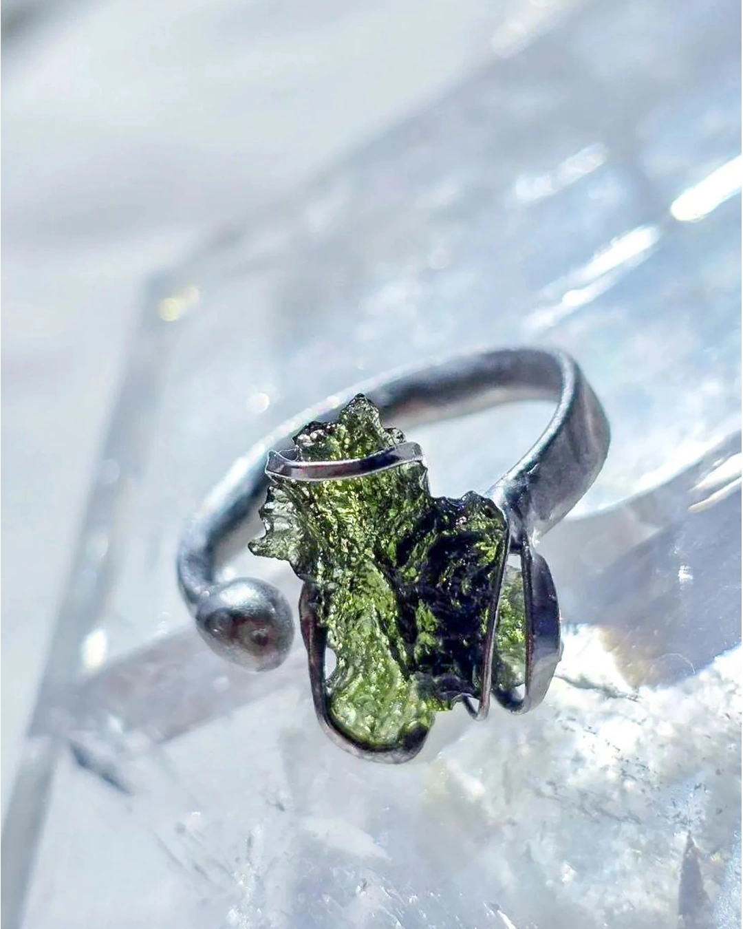 Adjustable moldavite ring with a 0.87g transparent green stone from Nesměň, featuring spiked sculpting in a tin and silver alloy setting.