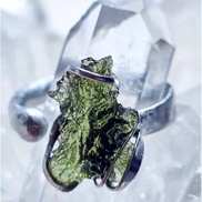 Adjustable moldavite ring with a 0.87g transparent green stone from Nesměň, featuring spiked sculpting in a tin and silver alloy setting.