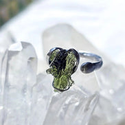 Adjustable moldavite ring with a 0.87g transparent green stone from Nesměň, featuring spiked sculpting in a tin and silver alloy setting.