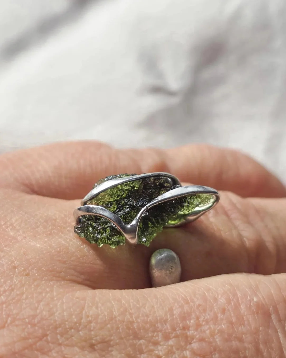 Adjustable ring with a genuine 1.23 g transparent green raw Moldavite from Chlum, Czech Republic, set in lead-free jewellery tin with silver admixture.
