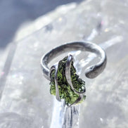 Adjustable ring with a genuine 1.23 g transparent green raw Moldavite from Chlum, Czech Republic, set in lead-free jewellery tin with silver admixture.
