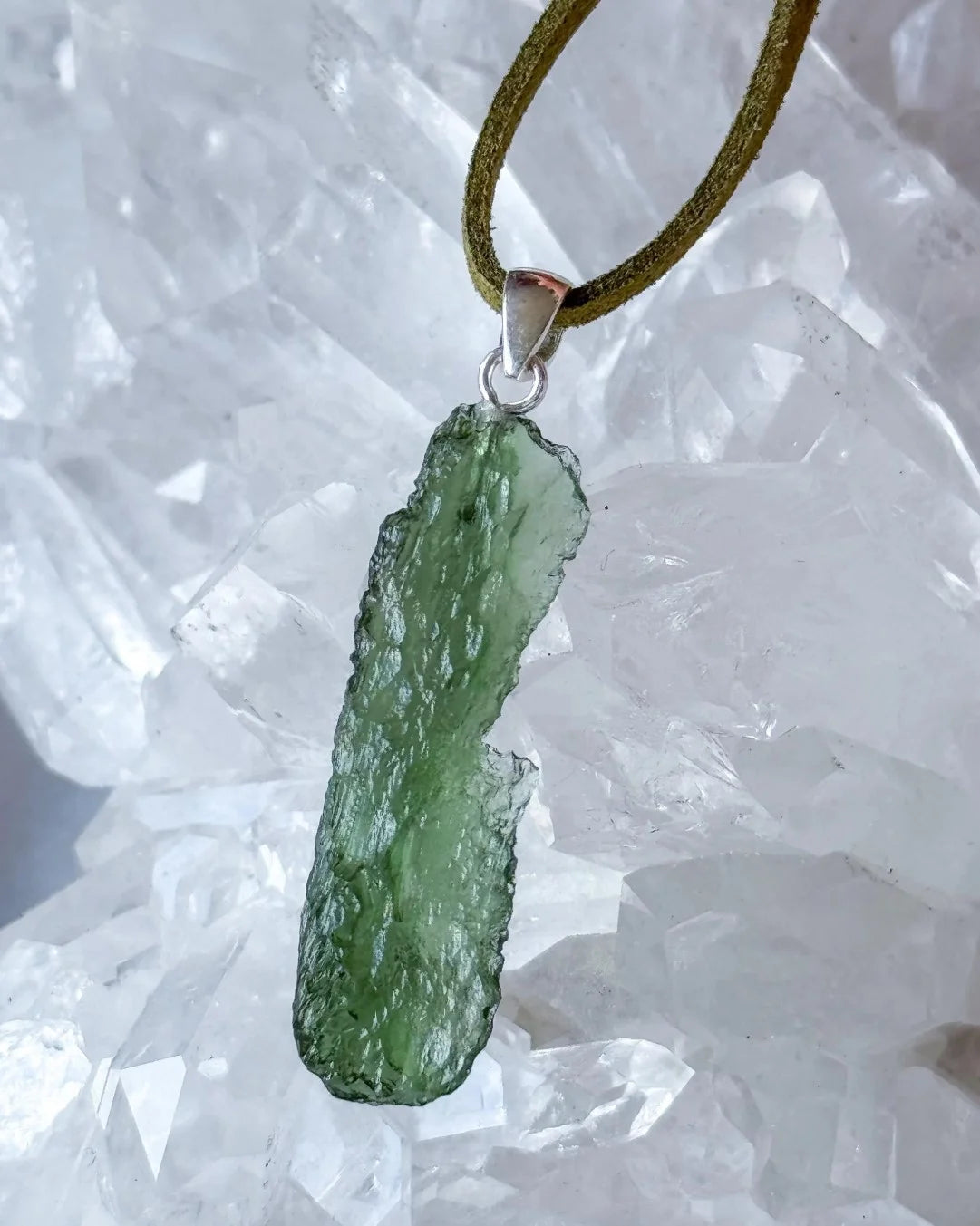 Transparent 3.6g Chlum Moldavite pendant with natural sculpted surface in sterling silver setting.