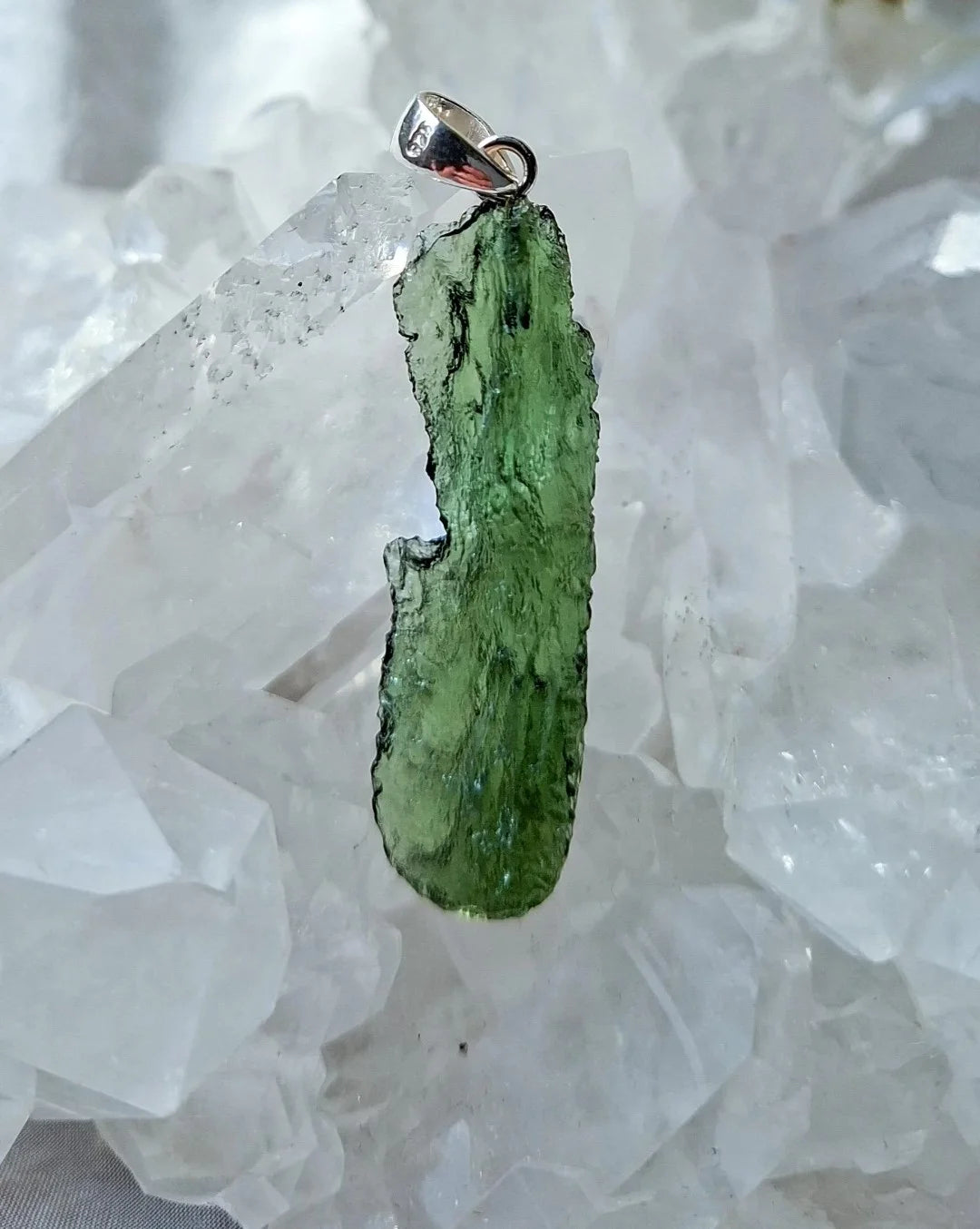 Transparent 3.6g Chlum Moldavite pendant with natural sculpted surface in sterling silver setting.