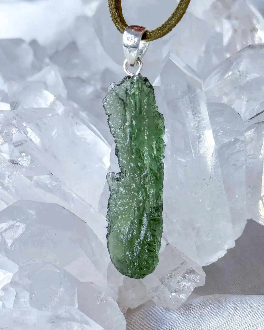 Transparent 3.6g Chlum Moldavite pendant with natural sculpted surface in sterling silver setting.
