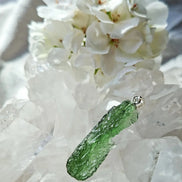 Transparent 3.6g Chlum Moldavite pendant with natural sculpted surface in sterling silver setting.