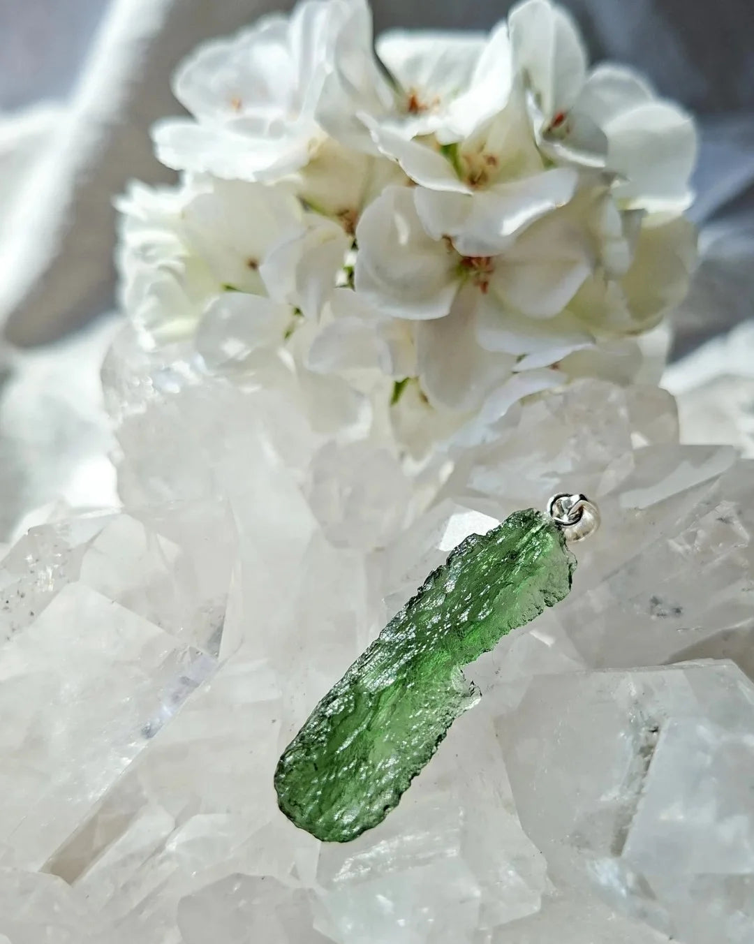 Transparent 3.6g Chlum Moldavite pendant with natural sculpted surface in sterling silver setting.