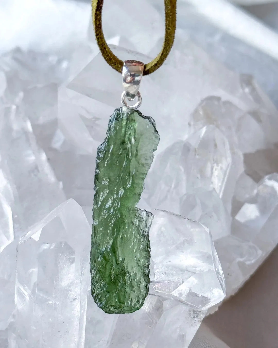 Transparent 3.6g Chlum Moldavite pendant with natural sculpted surface in sterling silver setting.