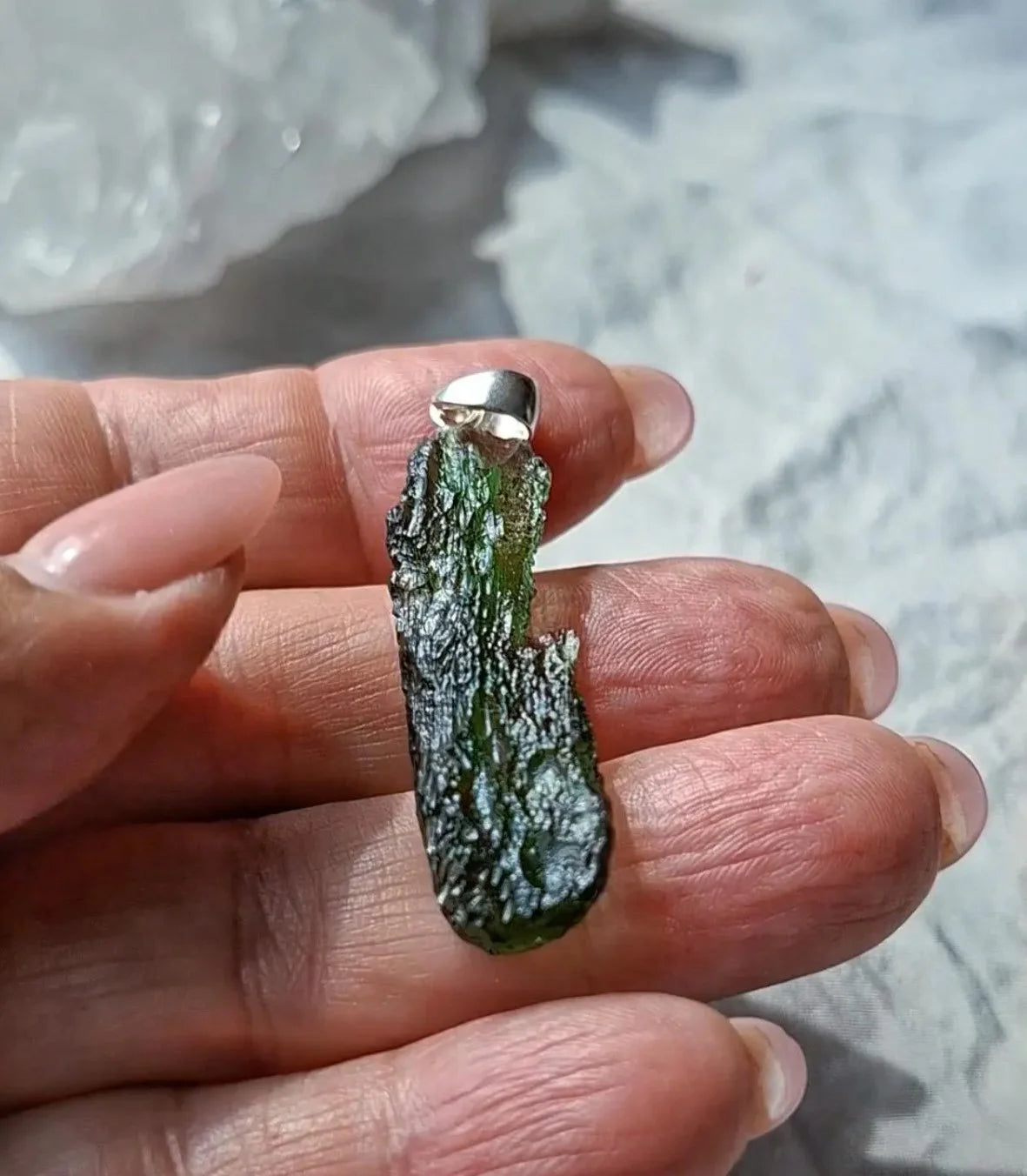 Transparent 3.6g Chlum Moldavite pendant with natural sculpted surface in sterling silver setting.