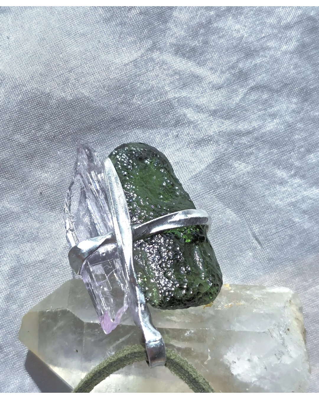 Pendant with 3.49g apple green moldavite from Ločenice and pale pink kunzite held by crossing metal bands.