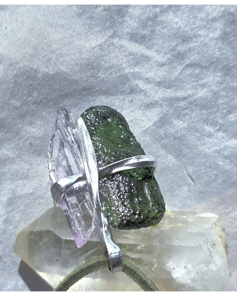Pendant with 3.49g apple green moldavite from Ločenice and pale pink kunzite held by crossing metal bands.