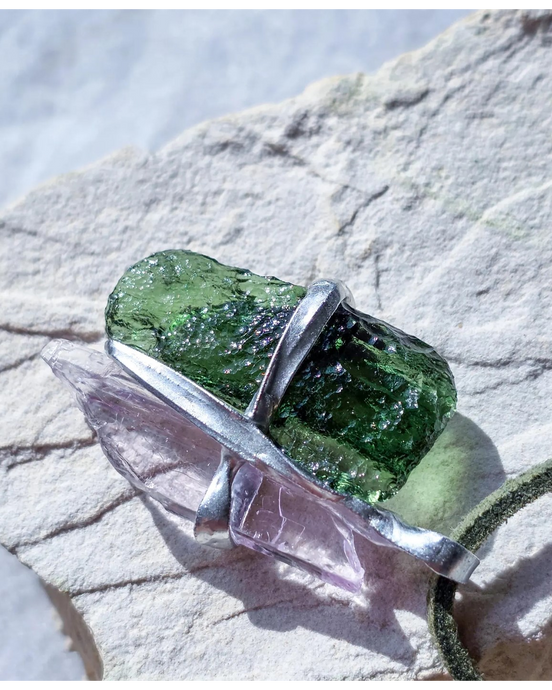 Pendant with 3.49g apple green moldavite from Ločenice and pale pink kunzite held by crossing metal bands.