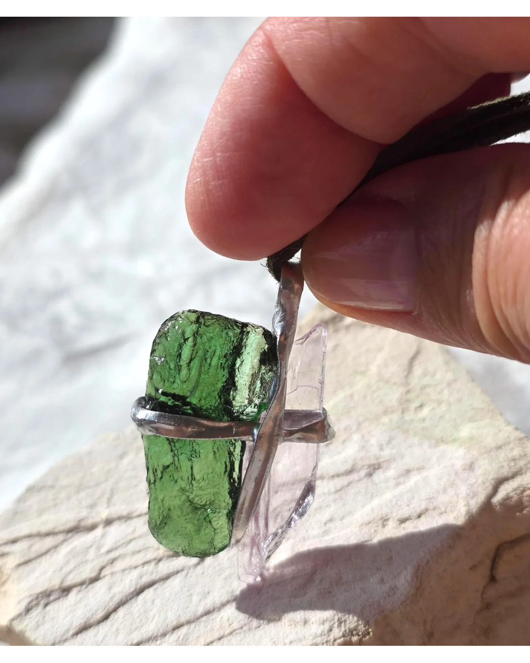 Pendant with 3.49g apple green moldavite from Ločenice and pale pink kunzite held by crossing metal bands.