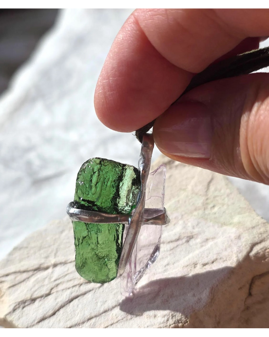 Pendant with 3.49g apple green moldavite from Ločenice and pale pink kunzite held by crossing metal bands.