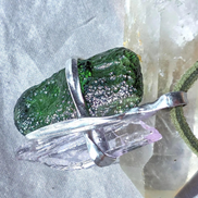 Pendant with 3.49g apple green moldavite from Ločenice and pale pink kunzite held by crossing metal bands.