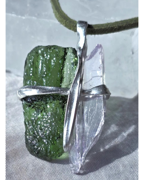 Pendant with 3.49g apple green moldavite from Ločenice and pale pink kunzite held by crossing metal bands.